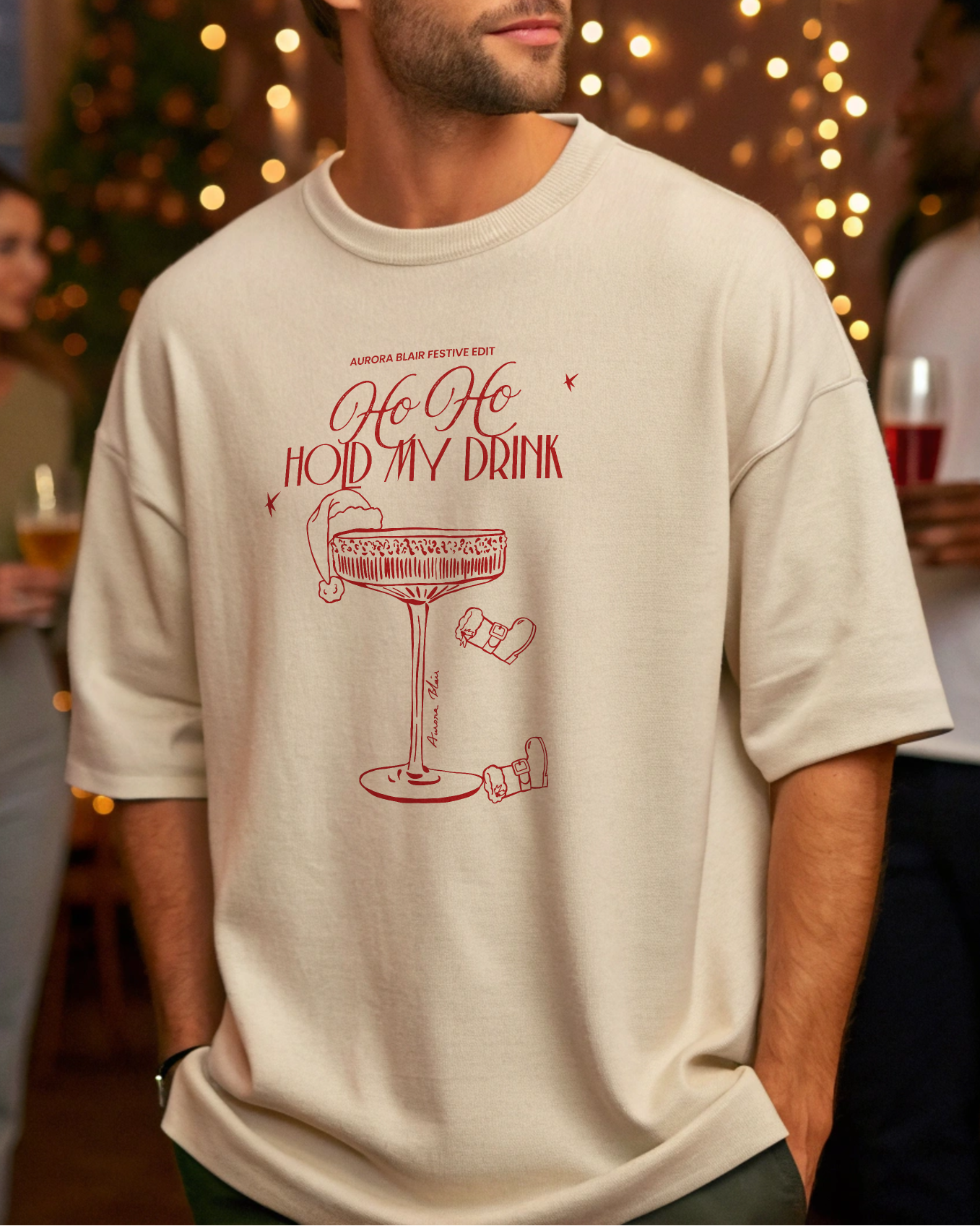 Man wearing a t-shirt with a festive design in a social setting with blurred people and lights.