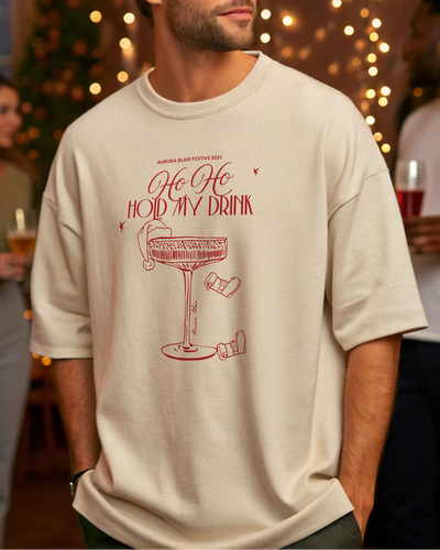 Man wearing a t-shirt with a festive design in a social setting with blurred people and lights.