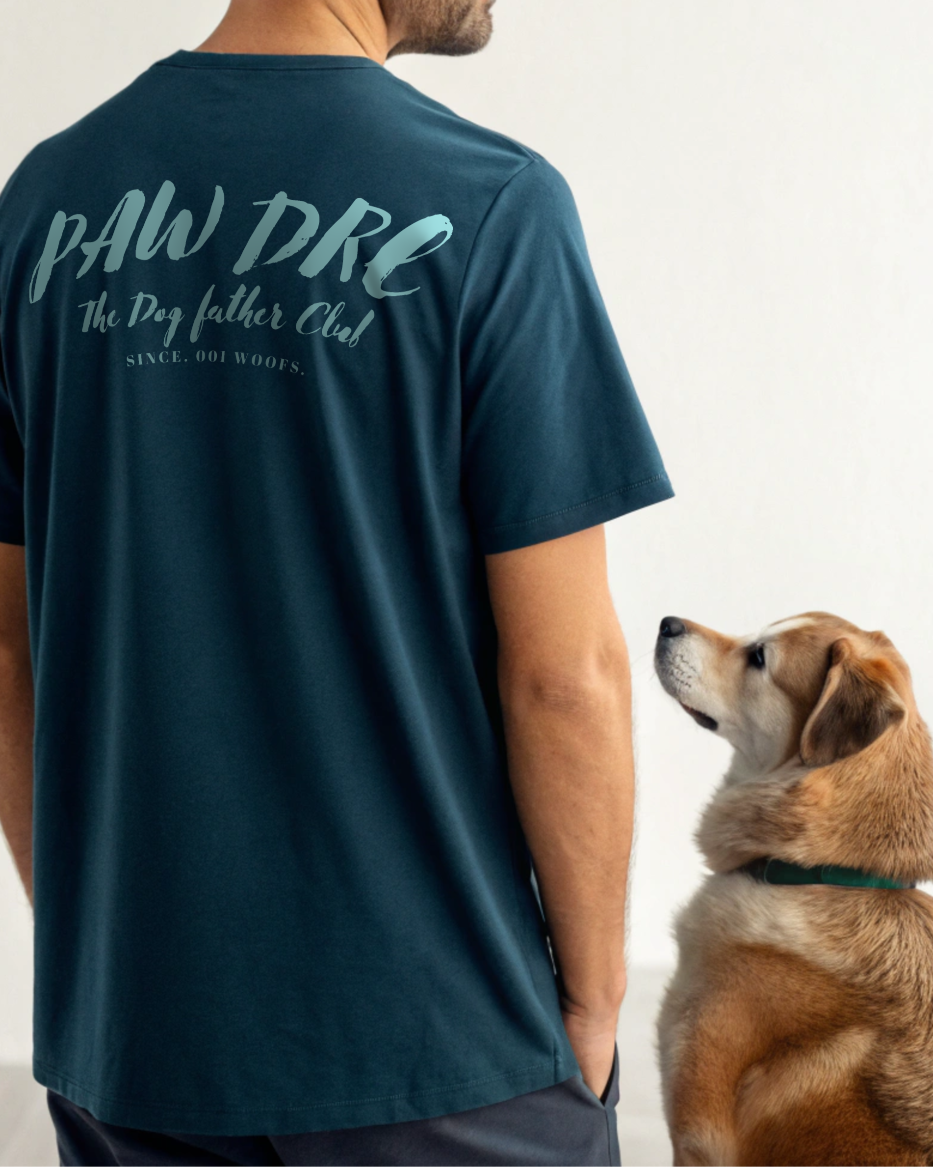 Man wearing a teal t-shirt with 'PAW DRE The Dog Father Club' text, standing next to a dog.